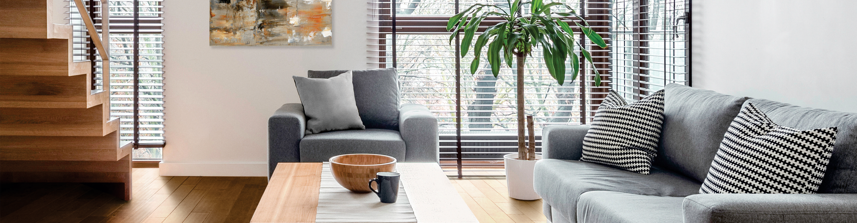 custom wood blinds in living room with grey furniture and wood flooring